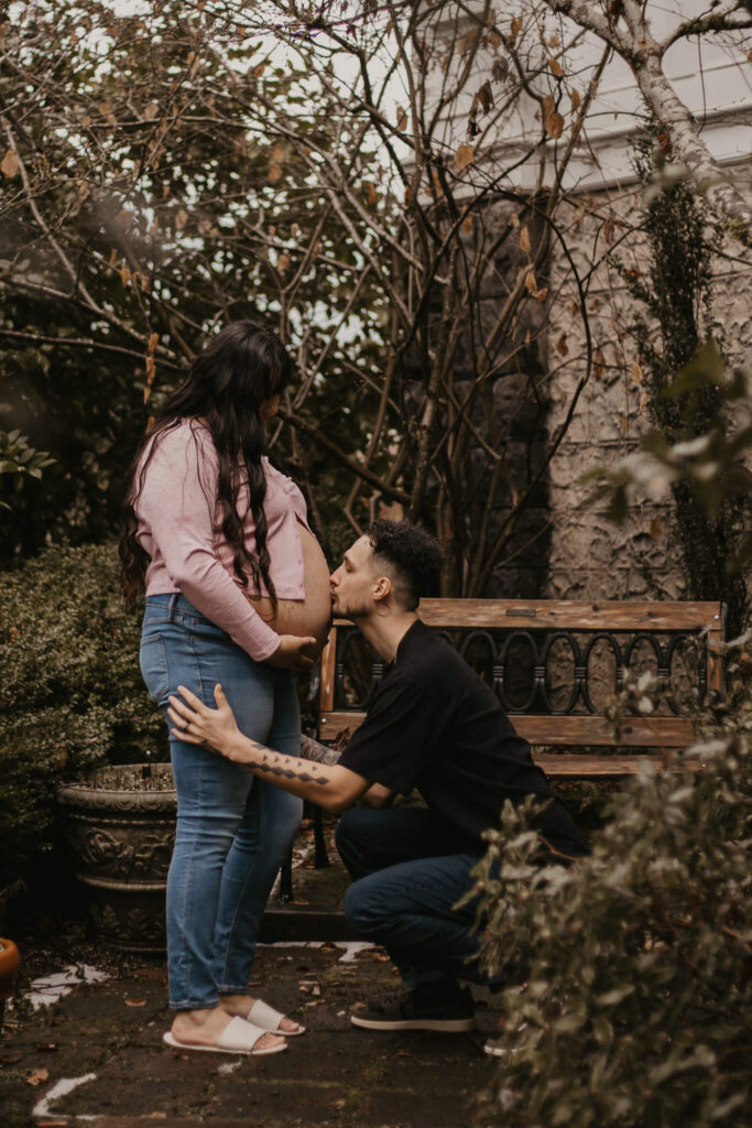 Husband kissing his wife's pregnant belly.